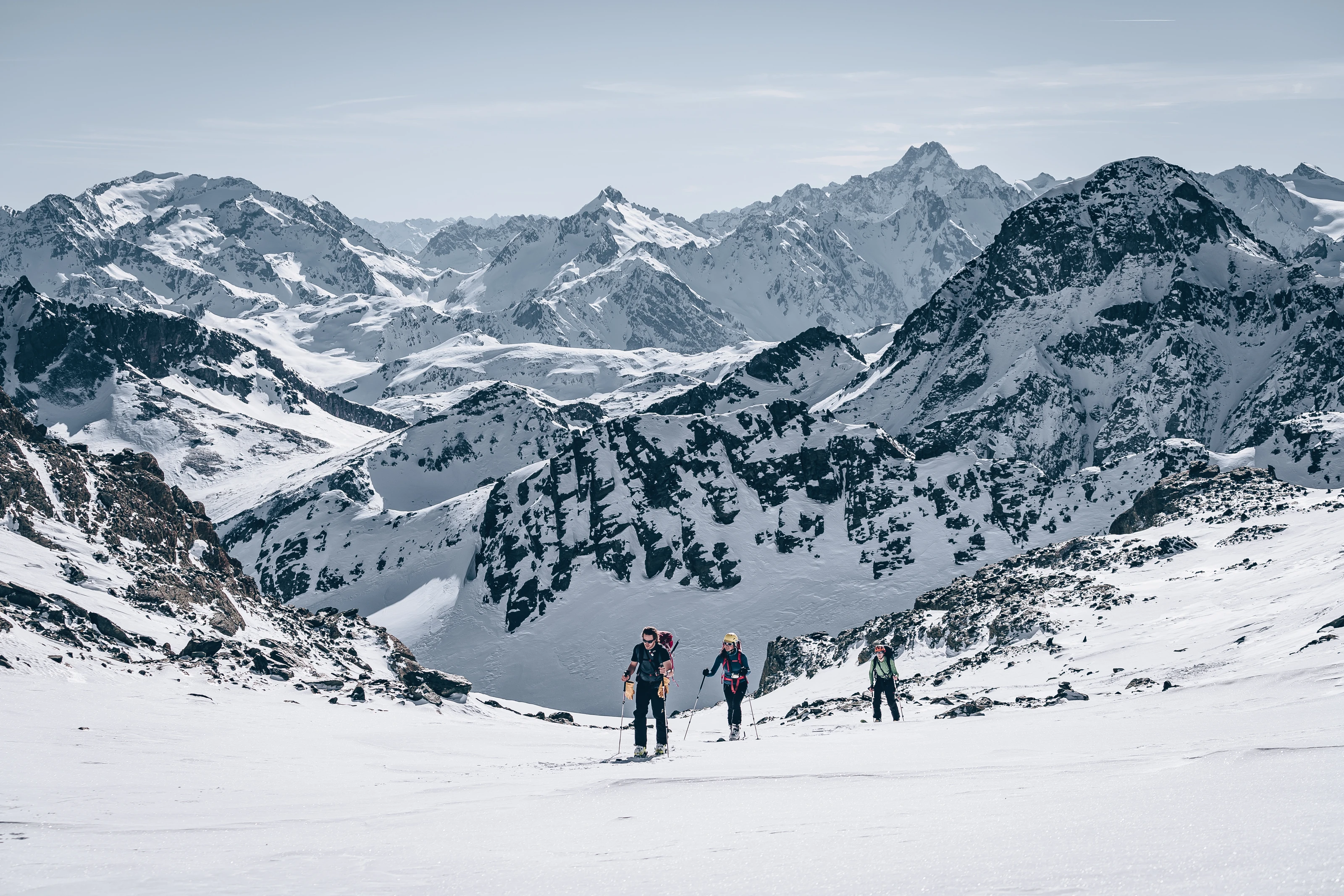 Weitwinkel-Schwarzweissfoto einer Wandergruppe beim Erreichen eines alpinen Gipfels