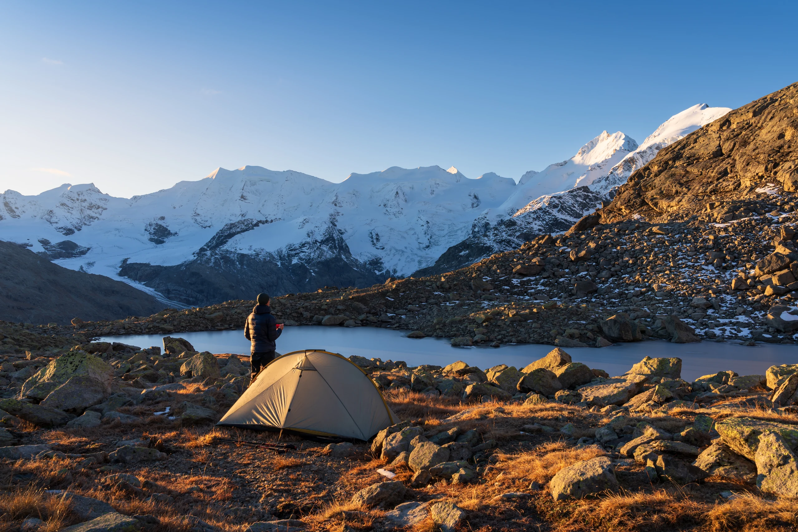 Wanderer am Morgenlager am Berninamassiv mit Blick auf schneebedeckte Gipfel
